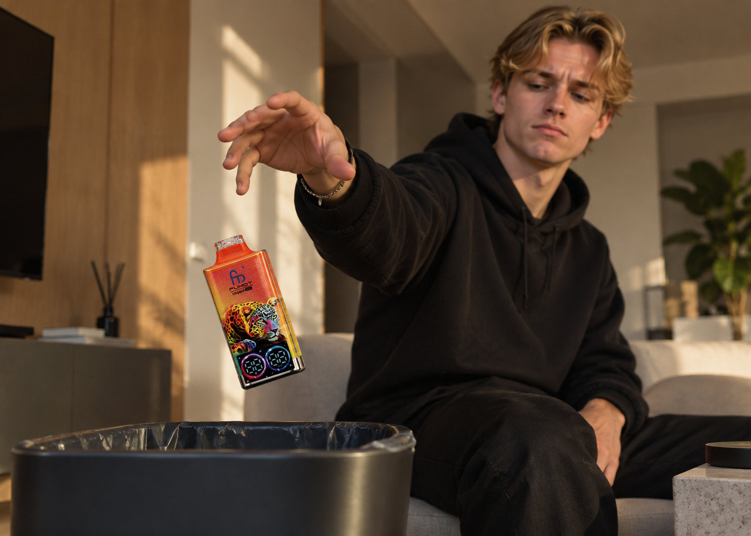 Junger Mann wirft eine leere Einweg Vape in einen Mülleimer